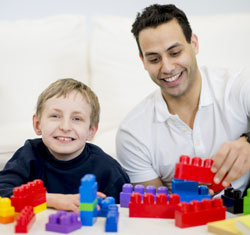 kid and man playing with building blocks
